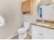 Well-lit half bathroom with granite countertop, white cabinets and a decorative round mirror at 16707 Broadford Ln, Clermont, FL 34714