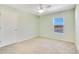 Bright bedroom featuring a ceiling fan, neutral carpet, and a window view of the waterfront at 16707 Broadford Ln, Clermont, FL 34714