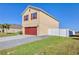 Two story home with red garage door, red shutters, and a gravel lined flower bed at 16707 Broadford Ln, Clermont, FL 34714