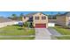 Well-maintained two-story home with red shutters, a spacious driveway, and a lush lawn at 16707 Broadford Ln, Clermont, FL 34714