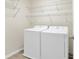 Bright laundry room with white washer and dryer, tile floor, and wire shelves at 16707 Broadford Ln, Clermont, FL 34714