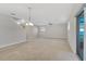Spacious living room with neutral carpet, large windows, and sliding glass doors to the patio at 16707 Broadford Ln, Clermont, FL 34714