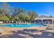 Sparkling pool surrounded by lounge chairs and a covered area on a sunny day, perfect for relaxation at 16707 Broadford Ln, Clermont, FL 34714