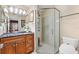 Well-lit bathroom with a granite countertop vanity, a glass-enclosed shower, and modern fixtures at 1685 Garcia Ct, The Villages, FL 32159