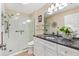 Stylish bathroom with a granite vanity top, spacious glass shower and modern fixtures at 1685 Garcia Ct, The Villages, FL 32159