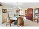 An elegant dining area showcases a chandelier, tiled floors, and access to the kitchen at 1685 Garcia Ct, The Villages, FL 32159