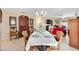 Dining room with seating for six, chandelier, and antique cabinet and hutch at 1685 Garcia Ct, The Villages, FL 32159