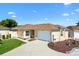 Charming single-story home featuring a well-manicured lawn, welcoming walkway, and attached garage at 1685 Garcia Ct, The Villages, FL 32159