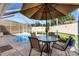 Screened-in pool area with patio table and chairs under an umbrella for outdoor dining at 1685 Garcia Ct, The Villages, FL 32159