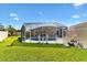 A wide view of the sparkling pool, patio, and yard in screened-in enclosure at 1685 Garcia Ct, The Villages, FL 32159