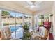 Bright sunroom features a ceiling fan, glass table, and views of the pool at 1685 Garcia Ct, The Villages, FL 32159