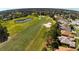 Scenic aerial view of residential neighborhood showcasing a nearby golf course, pond, and mature trees at 17274 Se 85Th Willowick Cir, The Villages, FL 32162