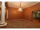 Formal dining room features a stunning chandelier, neutral carpet, and decorative columns at 17274 Se 85Th Willowick Cir, The Villages, FL 32162