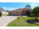 Charming home featuring a well-manicured lawn, paver driveway, and a spacious three-car garage at 17274 Se 85Th Willowick Cir, The Villages, FL 32162