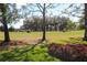 Picturesque golf course view featuring lush green grass, mature trees, and golf carts in the distance at 17274 Se 85Th Willowick Cir, The Villages, FL 32162