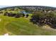 Scenic aerial view of the golf course and surrounding community, with lush green fairways and a tranquil pond at 17274 Se 85Th Willowick Cir, The Villages, FL 32162