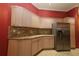 A kitchen with granite countertops, stainless steel refrigerator, and off-white cabinets against a red accent wall at 17274 Se 85Th Willowick Cir, The Villages, FL 32162