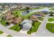 Aerial view of a home with a two-car garage, complemented by lush landscaping and a nearby lake at 17378 Se 110Th Ter, Summerfield, FL 34491