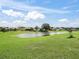 Expansive backyard view overlooking a serene pond with lush green grass and blue skies at 17378 Se 110Th Ter, Summerfield, FL 34491