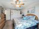 Bright bedroom featuring a ceiling fan, closet, and a cozy bed with blue floral bedding at 17378 Se 110Th Ter, Summerfield, FL 34491