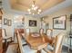 Traditional dining room with a large wood table, seating for six, and elegant chandelier at 17378 Se 110Th Ter, Summerfield, FL 34491
