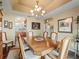 Traditional dining room boasts wood table with seating for six, elegant chandelier, and arched entries at 17378 Se 110Th Ter, Summerfield, FL 34491