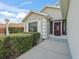 Close-up of a home's front entrance featuring a decorative door and trimmed hedges, enhancing curb appeal at 17378 Se 110Th Ter, Summerfield, FL 34491