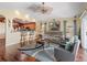 Open concept living room featuring wood floors, a ceiling fan, and views to the kitchen at 17378 Se 110Th Ter, Summerfield, FL 34491