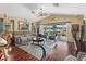 Inviting living room with wood floors, comfortable seating, and sliding glass doors to a screened patio at 17378 Se 110Th Ter, Summerfield, FL 34491