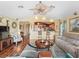 Cozy living room showing bar seating to the kitchen, wood flooring, ceiling fan, and open layout at 17378 Se 110Th Ter, Summerfield, FL 34491