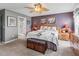 Comfortable main bedroom features carpet, ceiling fan, a large window, dresser, and a decorative accent wall at 17378 Se 110Th Ter, Summerfield, FL 34491