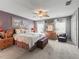 Comfortable main bedroom features carpet, ceiling fan, a large window, dresser, and a decorative accent wall at 17378 Se 110Th Ter, Summerfield, FL 34491