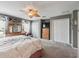 Spacious main bedroom featuring carpet, ceiling fan, dresser, walk-in closet, and a decorative accent wall at 17378 Se 110Th Ter, Summerfield, FL 34491