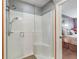 Modern shower with glass enclosure, tiled floor, and a view to the adjacent bedroom at 17378 Se 110Th Ter, Summerfield, FL 34491