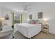 Bright bedroom features white bedding, a modern desk, and lots of natural light at 1755 Lakewood Dr, The Villages, FL 32162