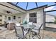 Outdoor dining area with stone flooring and screened-in patio with comfortable wicker seating at 1755 Lakewood Dr, The Villages, FL 32162