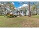 View of the back of the home featuring mature trees and lush tropical plants at 17561 Seidner Rd, Winter Garden, FL 34787