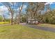 Manicured front yard features a long driveway leading to a white outbuilding and blooming pink flowers at 17561 Seidner Rd, Winter Garden, FL 34787