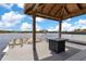 Gazebo on a private dock with seating and a table overlooking a serene lake and boat at 17561 Seidner Rd, Winter Garden, FL 34787