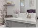 Close-up on bathroom vanity featuring gray cabinets and a decorative vase at 17834 Se 105Th Ave, Summerfield, FL 34491