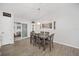 Bright dining room features sliding glass doors, modern lighting, and stylish gray wood flooring at 17834 Se 105Th Ave, Summerfield, FL 34491