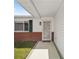 Inviting front entryway with a charming storm door, green shutters and brick accents at 17834 Se 105Th Ave, Summerfield, FL 34491