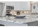 A close up on a modern kitchen island with granite countertops and stainless steel appliances at 17834 Se 105Th Ave, Summerfield, FL 34491