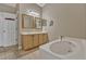 Bright bathroom with double sinks, framed mirrors, and a large tub for ultimate relaxation at 1787 Sunset Ridge Dr, Mascotte, FL 34753