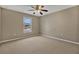 Neutral colored room with a ceiling fan, carpeted floors, and a large window for ample natural lighting at 1787 Sunset Ridge Dr, Mascotte, FL 34753