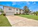 Charming two-story home with a well-manicured lawn and lush greenery at 1787 Sunset Ridge Dr, Mascotte, FL 34753