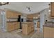 This kitchen has a center island with stainless appliances, wooden cabinets and light countertops at 1787 Sunset Ridge Dr, Mascotte, FL 34753