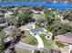 Stunning aerial view of home with circular driveway, lush landscaping, and beautiful lake in the background at 1930 Hilltop Dr, Mount Dora, FL 32757