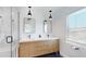 Modern bathroom featuring a double vanity with wood cabinets, black fixtures, and pendant lighting at 1930 Hilltop Dr, Mount Dora, FL 32757