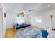 Bright bedroom with hardwood floors, a play teepee, and a blue bed beneath colorful lantern decorations at 1930 Hilltop Dr, Mount Dora, FL 32757